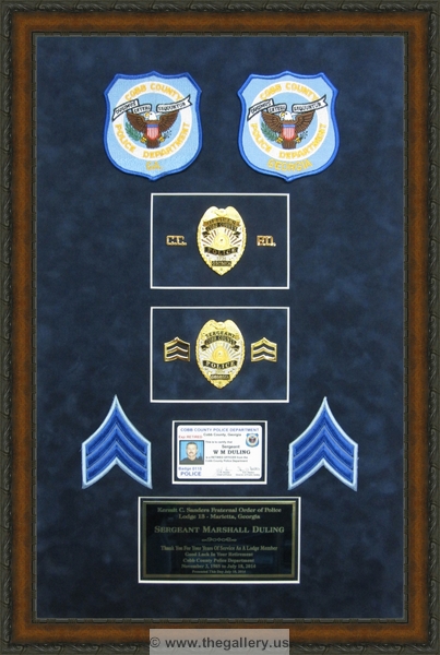 Police Department retirement shadow box with police badges, patches, ID cards and lapel pins.






The Gallery at Brookwood
www.thegallery.us
770-941-3394
Your Custom Framing Expert
Picture Framing Examples
Custom Framing Examples
Shadowbox Examples
Police_shadow_box_with_badges