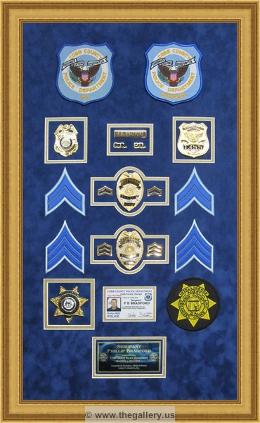 Cobb County Police Department retirement shadow box with police badges, patches, ID cards and lapel pins.






The Gallery at Brookwood
www.thegallery.us
770-941-3394
Your Custom Framing Expert
Picture Framing Examples
Custom Framing Examples
Shadowbox Examples
police_department_shadow_box