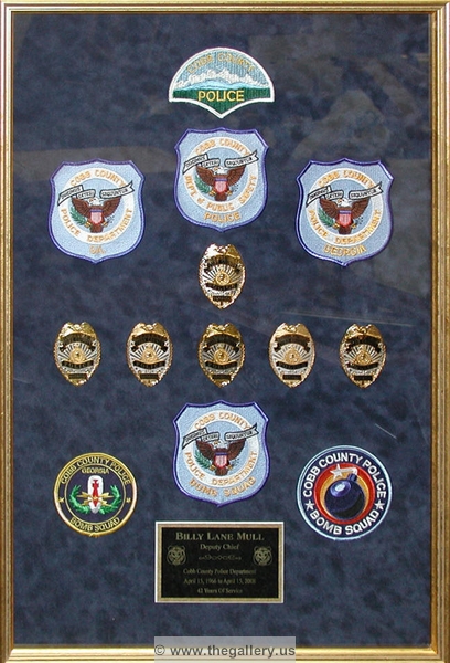 Police Department retirement shadow box with police badges, patches, ID cards and lapel pins.






The Gallery at Brookwood
www.thegallery.us
770-941-3394
Your Custom Framing Expert
Picture Framing Examples
Custom Framing Examples
Shadowbox Examples
police_ret