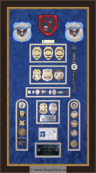 Police Department retirement shadow box with police badges, patches, ID cards and lapel pins.






The Gallery at Brookwood
www.thegallery.us
770-941-3394
Your Custom Framing Expert
Picture Framing Examples
Custom Framing Examples
Shadowbox Examples
police_shadowbox_