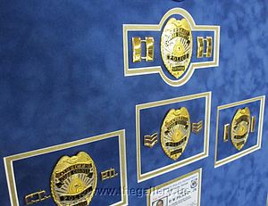 Detail view of Cobb County Police Department retirement shadow box with police badges, patches, ID cards and lapel pins.

The Gallery at Brookwood
www.thegallery.us
770-941-3394
Your Custom Framing Expert
Picture Framing Examples
Custom Framing Examples
Shadowbox Examples